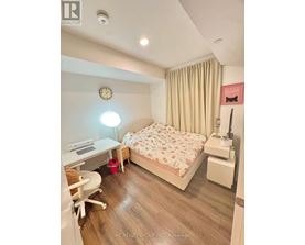 A bedroom with a bed, desk, and chair.