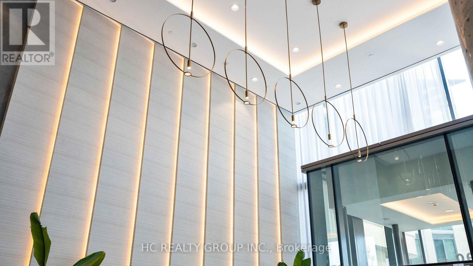 A modern interior space with a glass wall and a hanging light fixture.