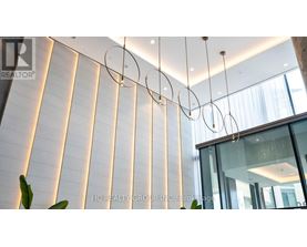 A modern interior space with a glass wall and a hanging light fixture.