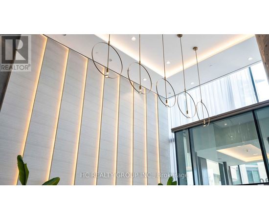 A modern interior space with a glass wall and a hanging light fixture.