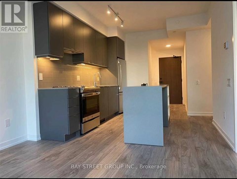 A kitchen with dark wood cabinets and a white countertop.