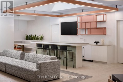 A modern living room with a grey sofa and a television mounted on the wall.