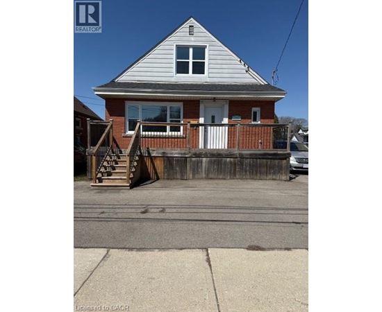 A house with a grey roof and a red brick wall.
