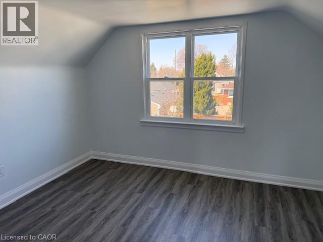 A room with a window showing a view of a tree and a building outside.