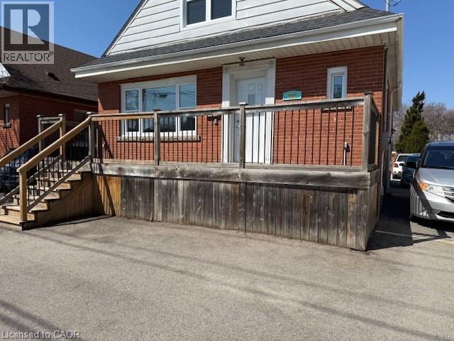 A house with a wooden fence and a car parked in front.