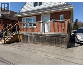 A house with a wooden fence and a car parked in front.