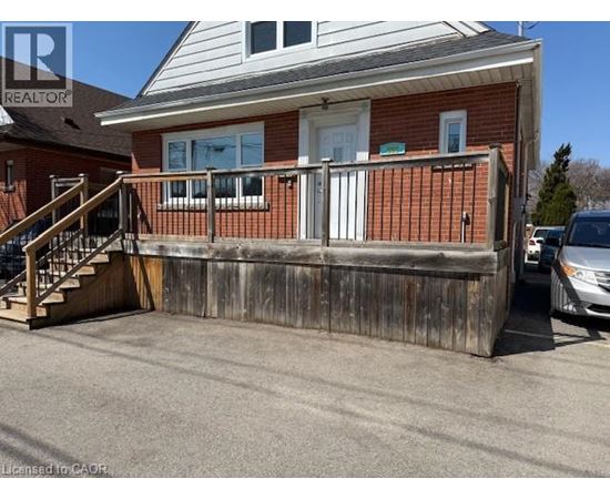 A house with a wooden fence and a car parked in front.