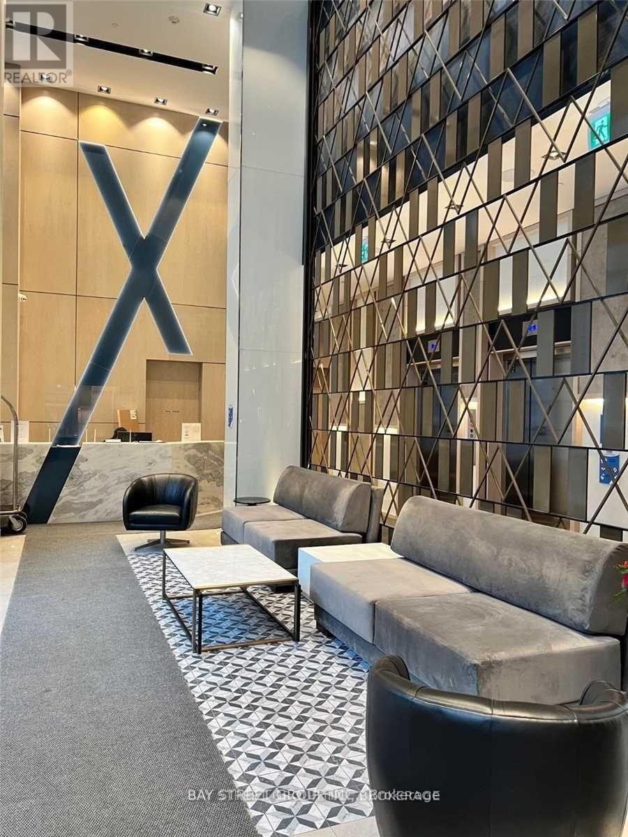 A large X is on the wall in a room with a glass block wall.