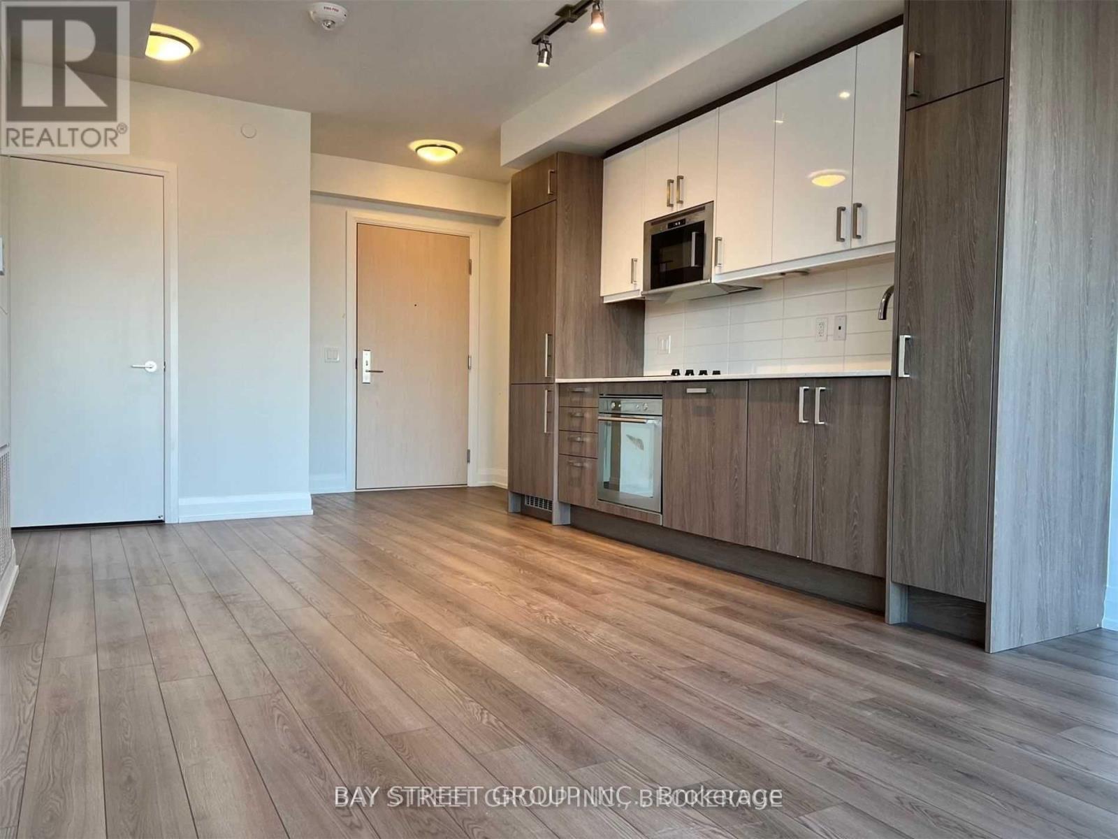 A spacious kitchen with wooden floors and modern appliances.