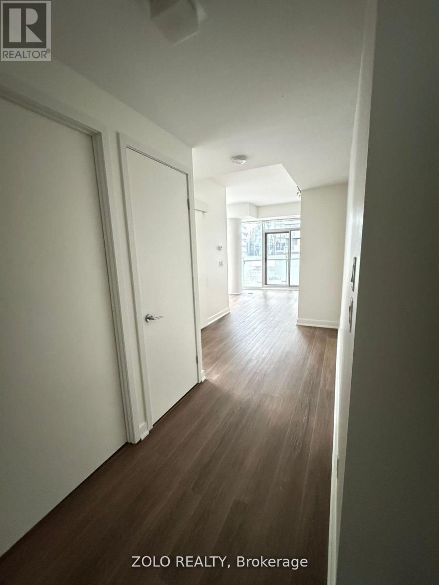 A hallway with wood flooring and white walls.