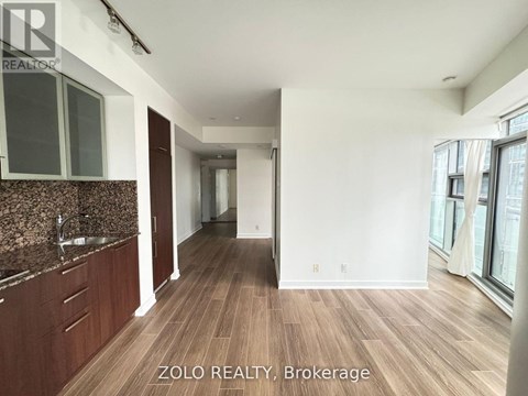 A spacious kitchen with brown cabinets and a granite countertop.