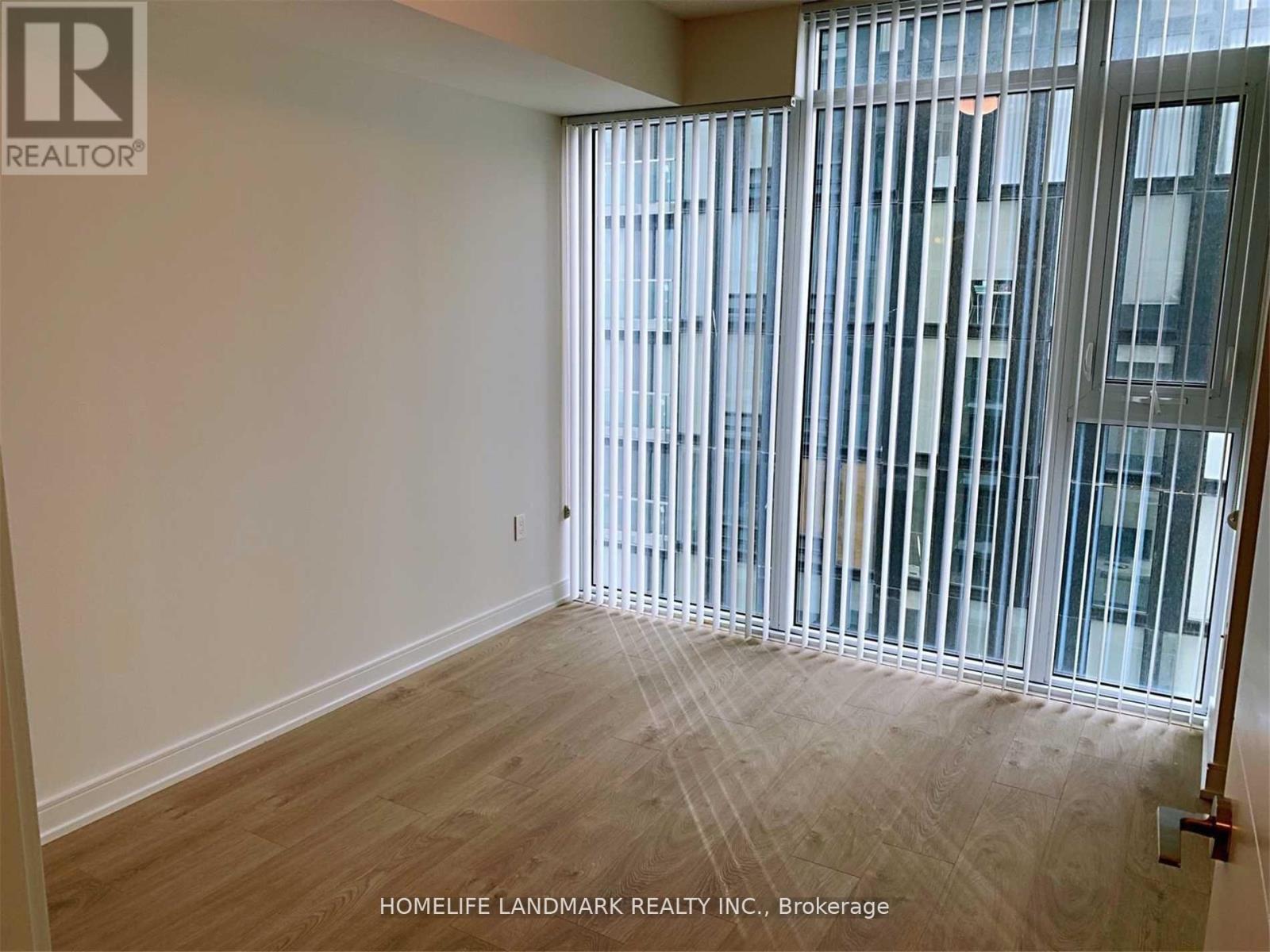 A room with a sliding glass door leading to a balcony.