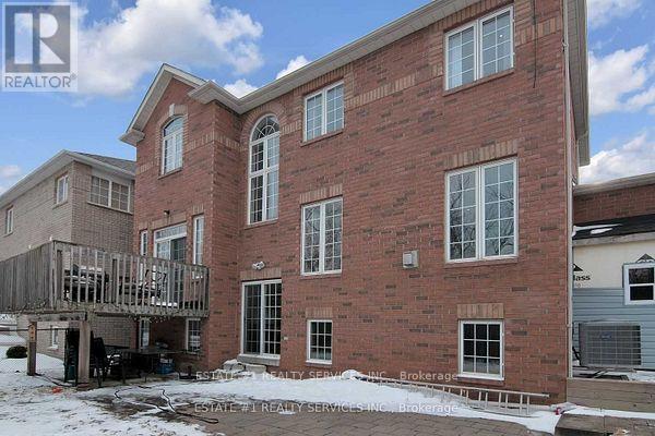 A red brick house with a balcony and a sign that says REALTOR.