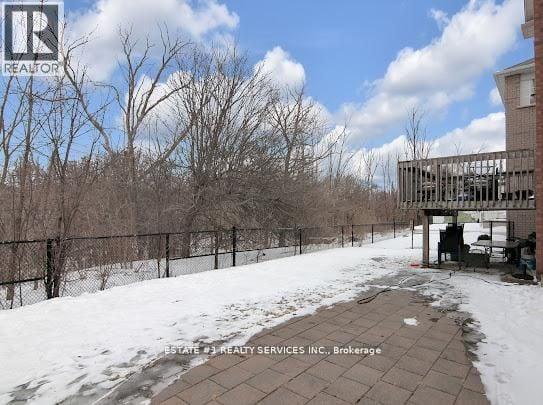 A snowy landscape with a fence and a building in the background.