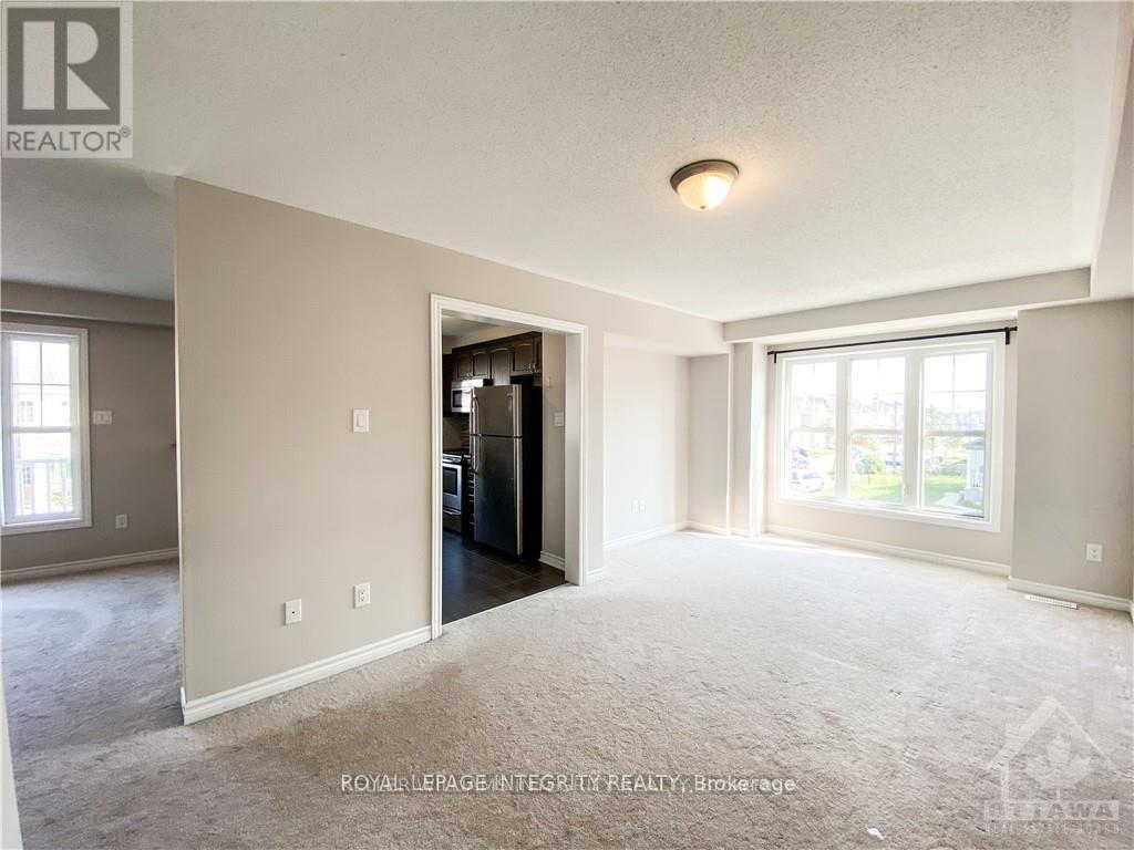 A spacious room with a doorway leading to another room.
