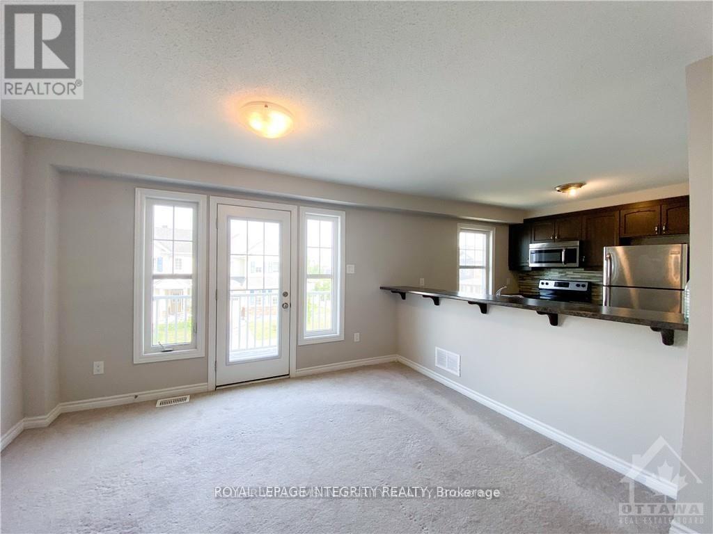 A spacious living room with a flat-screen TV mounted on the wall.