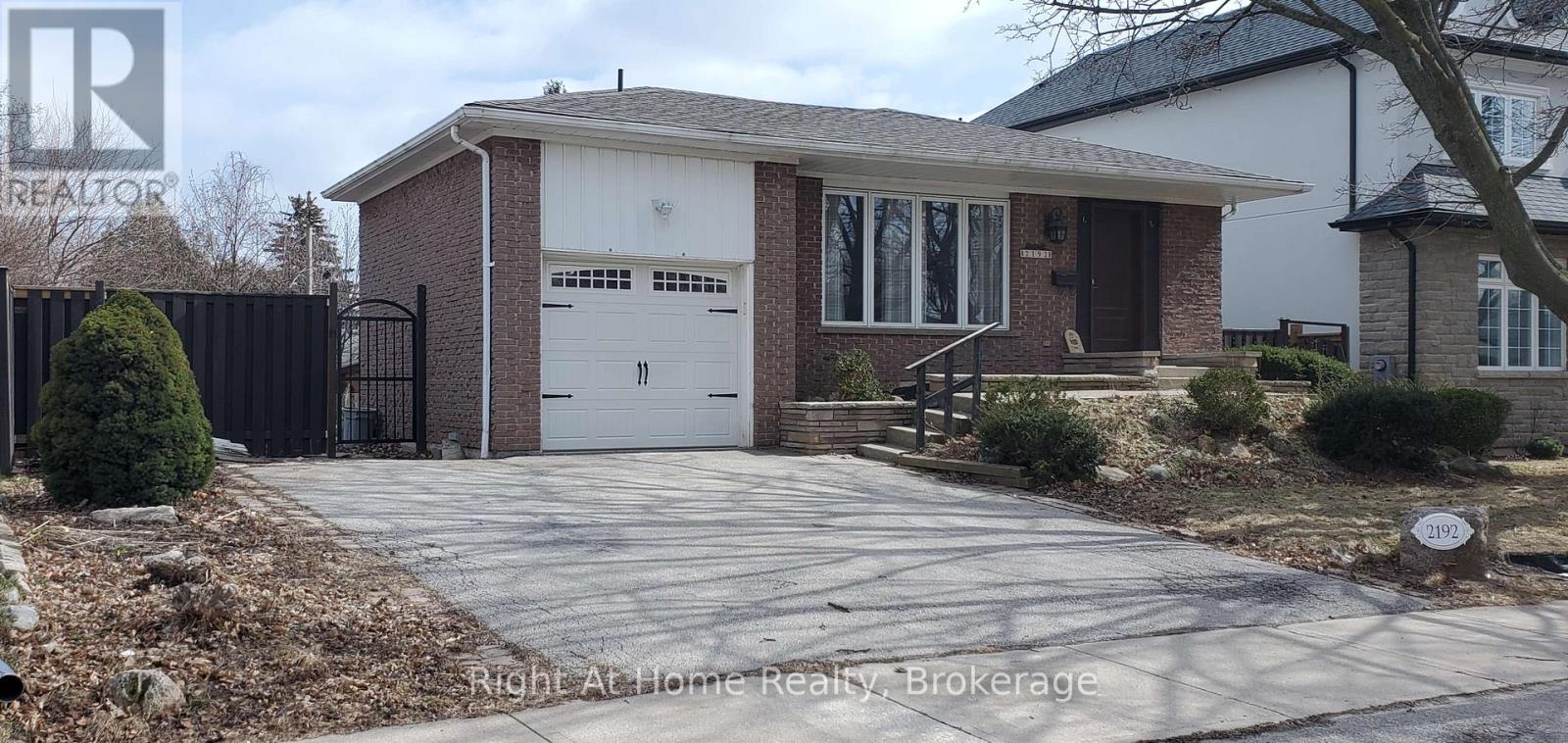A house with a garage and a driveway in front of it.