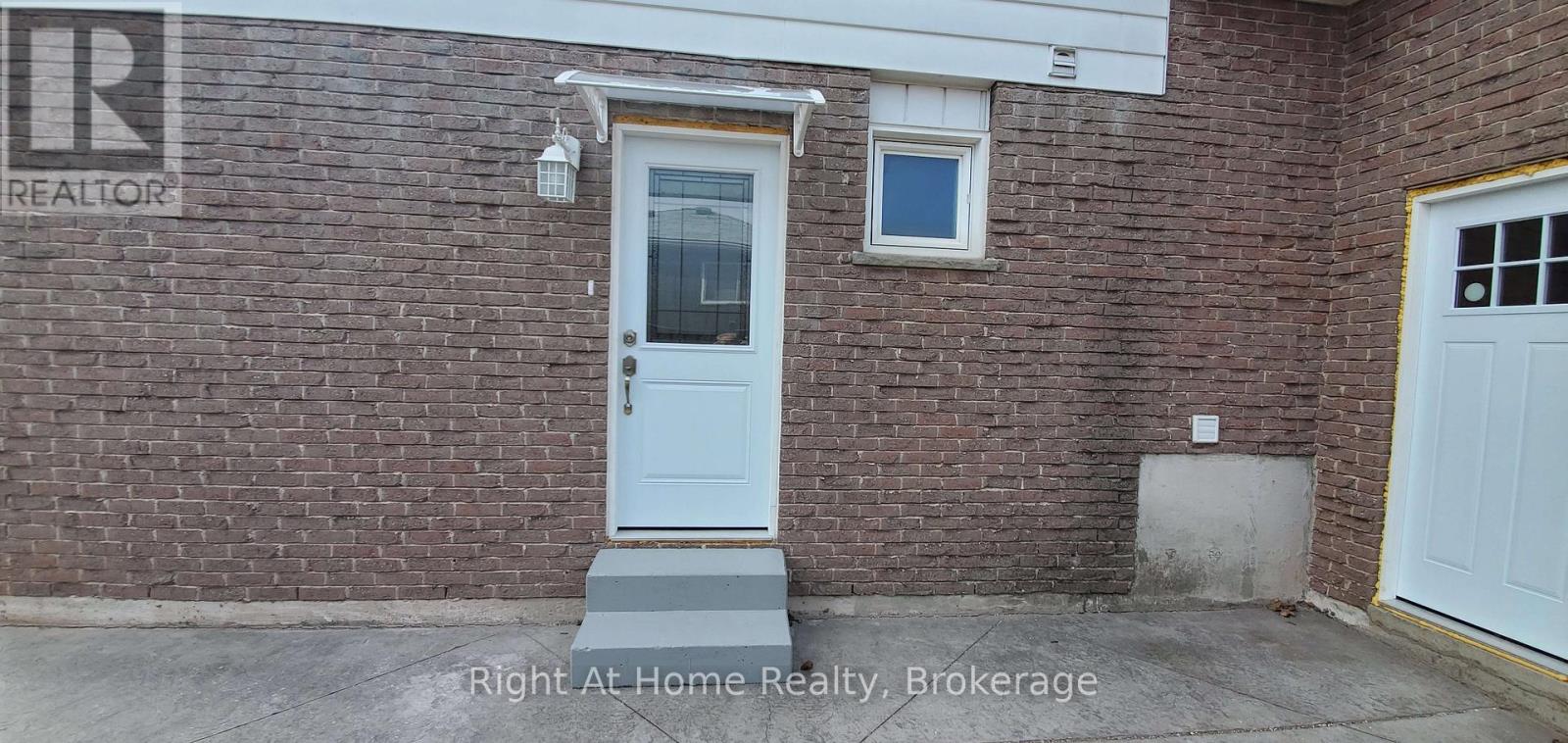 A brick house with a white door and a window.