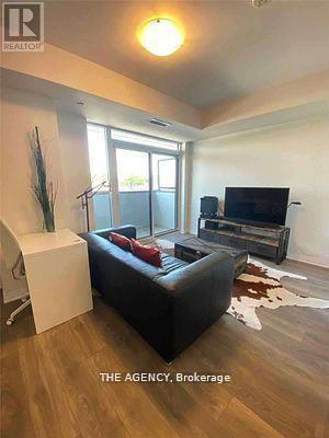A living room with a black couch and a television.