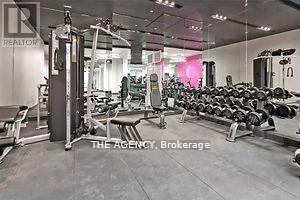A gym with a variety of equipment including dumbbells and weight machines.