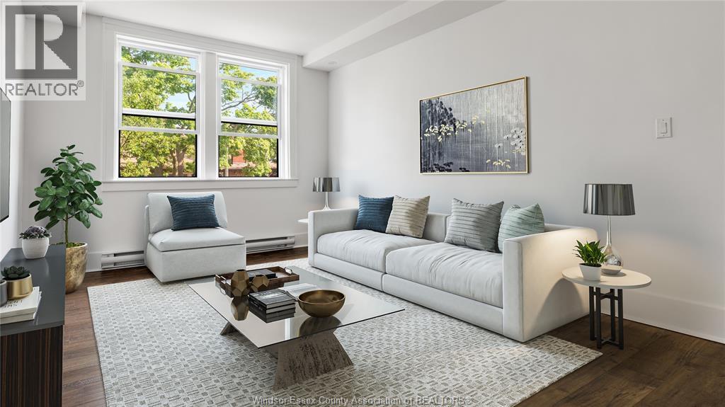 A living room with a white couch, a coffee table, and a large window.