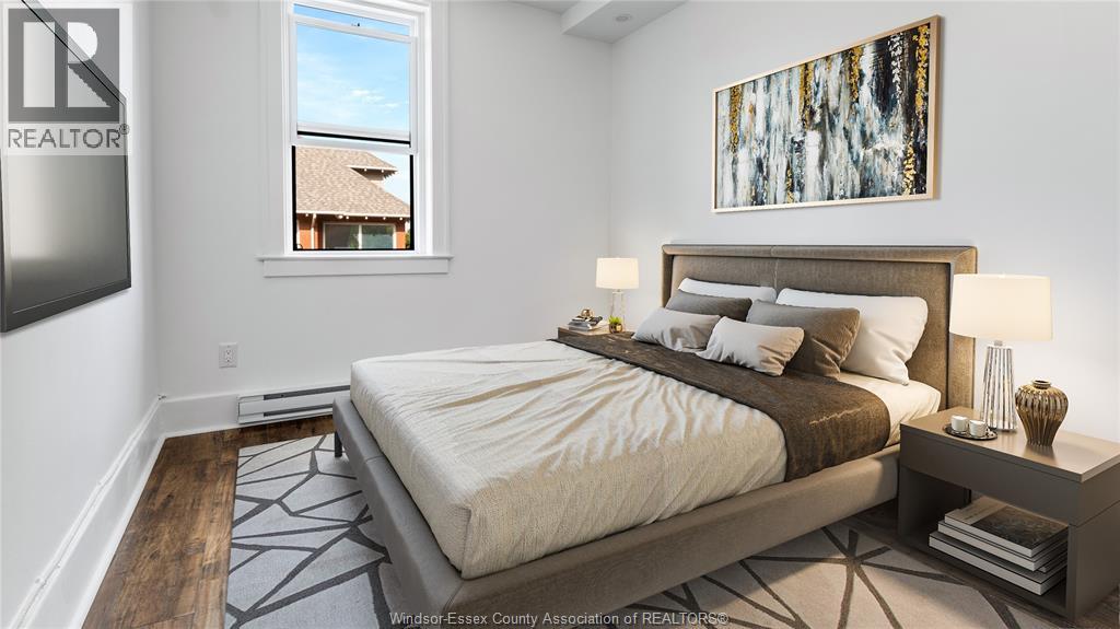 A bedroom with a large bed, a nightstand, and a painting on the wall.