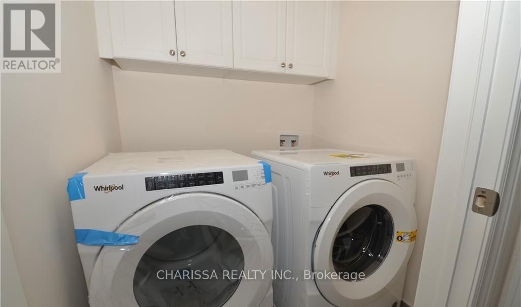 Two Whirlpool washing machines are in a small laundry room.
