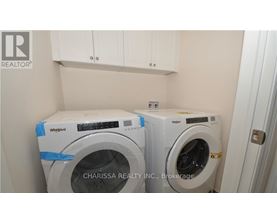 Two Whirlpool washing machines are in a small laundry room.