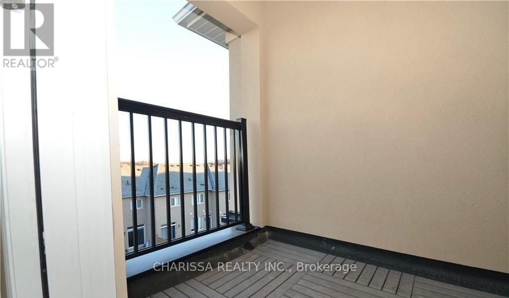 A balcony with a black railing and a view of buildings outside.