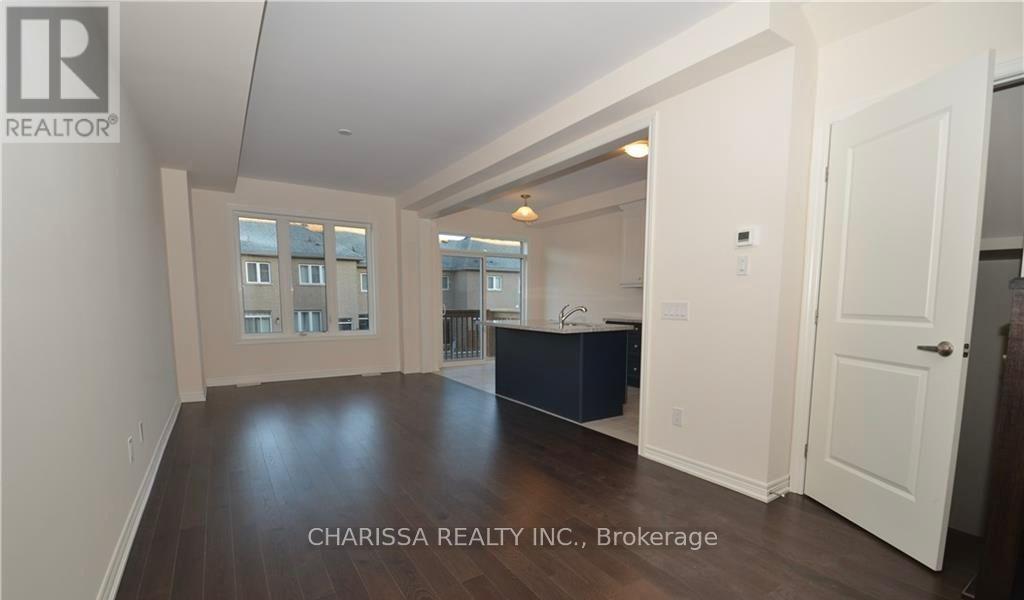 A spacious room with wood flooring and white walls, furnished with a dark blue cabinet.