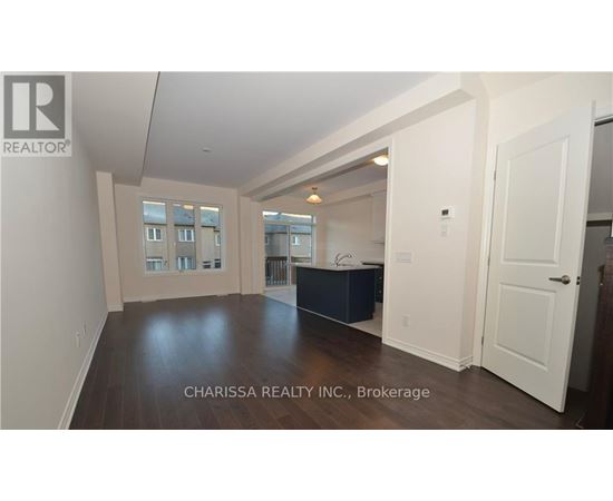 A spacious room with wood flooring and white walls, furnished with a dark blue cabinet.