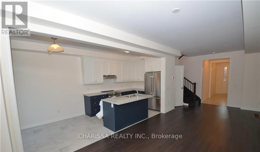 A spacious kitchen with white cabinets and a dark island.