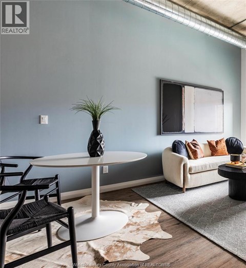 A living room with a white table and a couch with pillows.