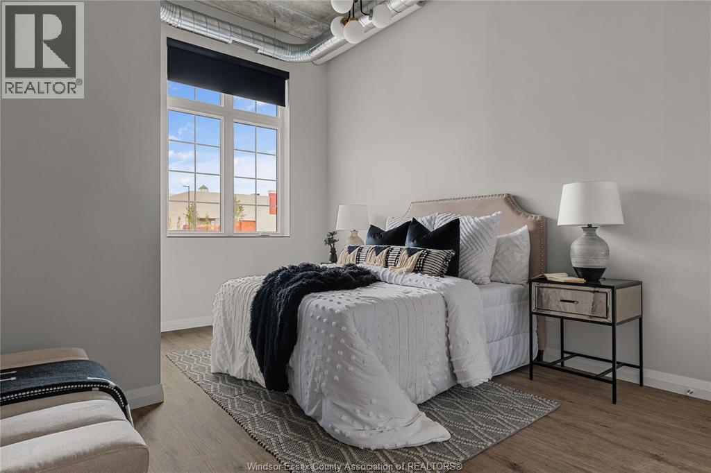 A bedroom with a bed, nightstand, and window.