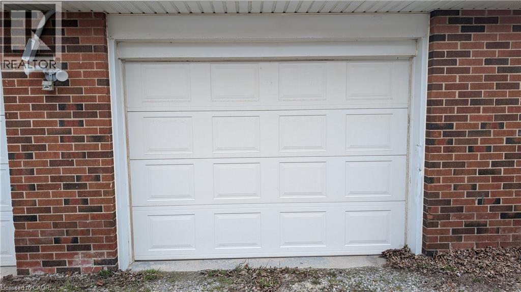 A white garage door is closed and has a sign above it that says "REALTOR".
