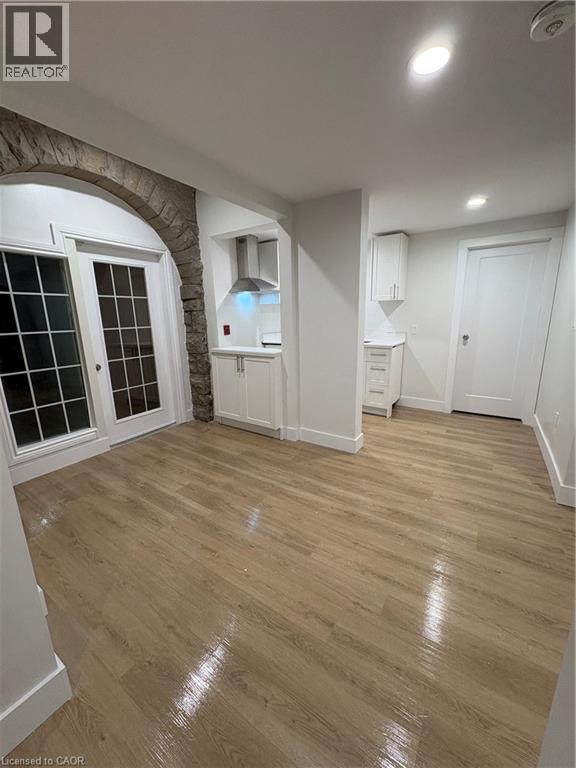 A room with wooden flooring and white walls.