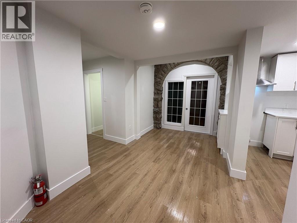 A room with a stone archway and wooden flooring.