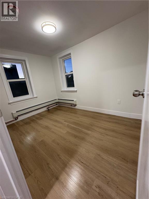 A room with wooden flooring and a window.