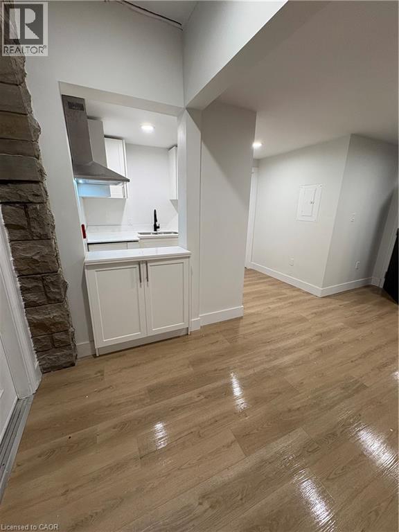 A kitchen with white cabinets and a stone pillar.