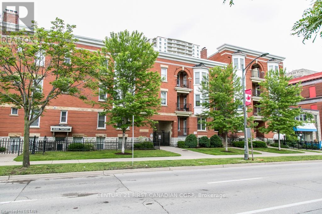 A red brick building with a black fence in front.