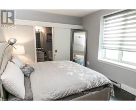 A bedroom with a large bed and a mirror on the wall.