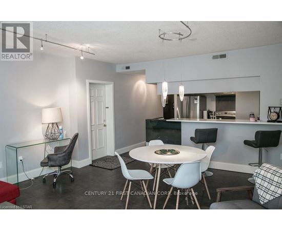 A modern dining room with a glass table and chairs.