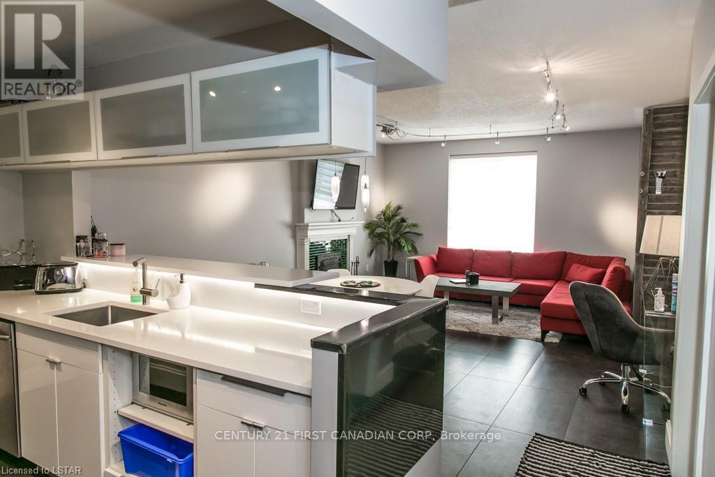A modern kitchen with a red couch and a television.