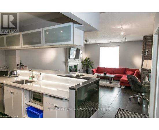 A modern kitchen with a red couch and a television.