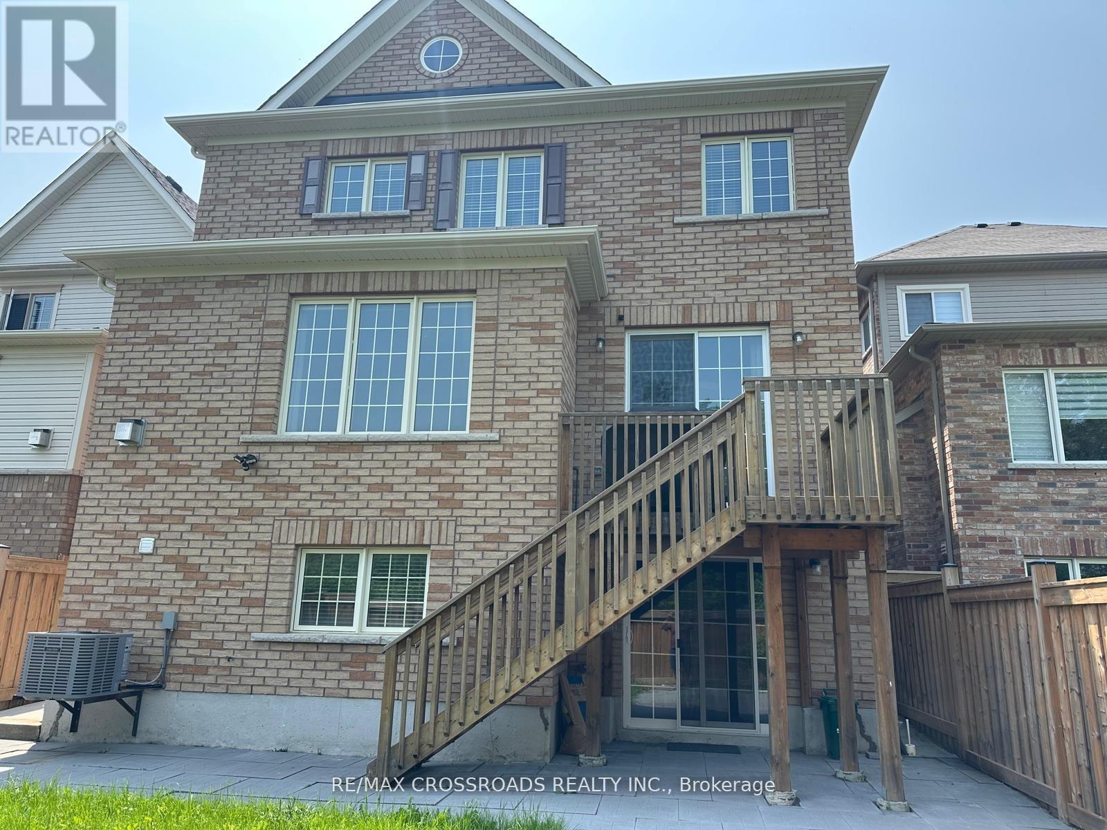 A house with a brick facade and a wooden deck.