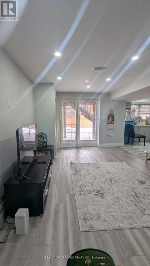 A living room with a television and a rug on the floor.