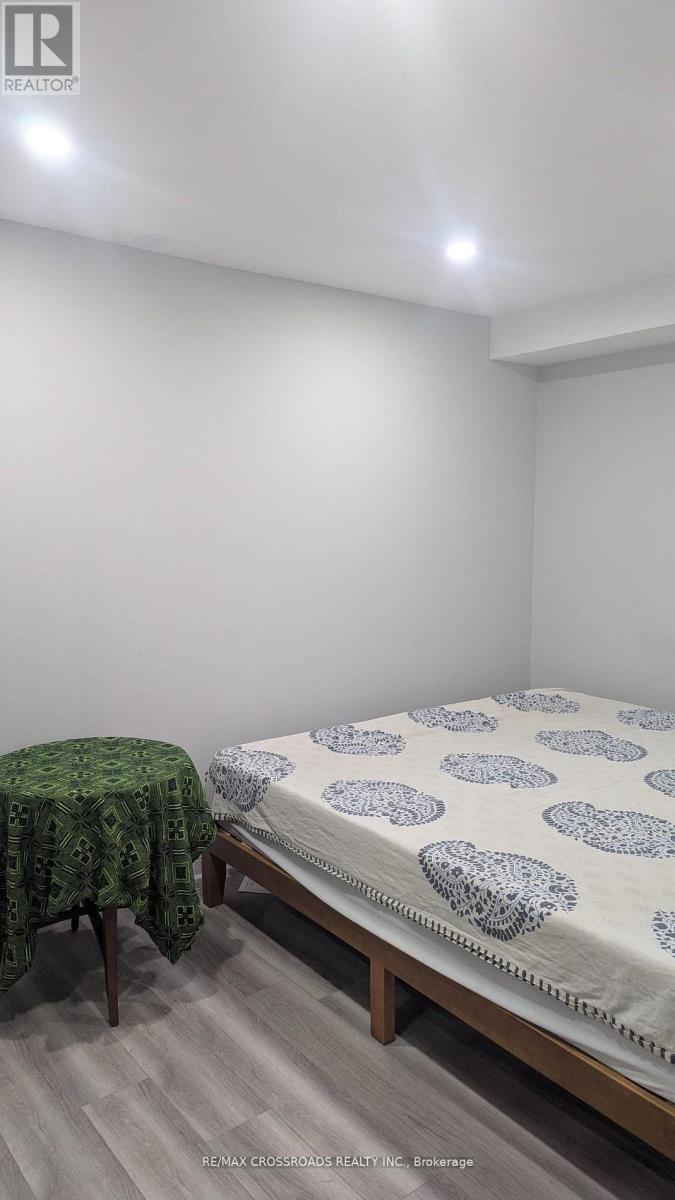 A bedroom with a bed and a chair.