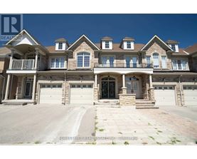 A large, multi-level house with a stone facade and multiple garages.