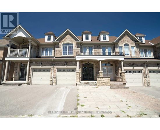 A large, multi-level house with a stone facade and multiple garages.