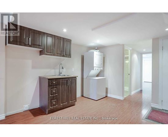 A kitchen area with wooden cabinets and a white refrigerator.